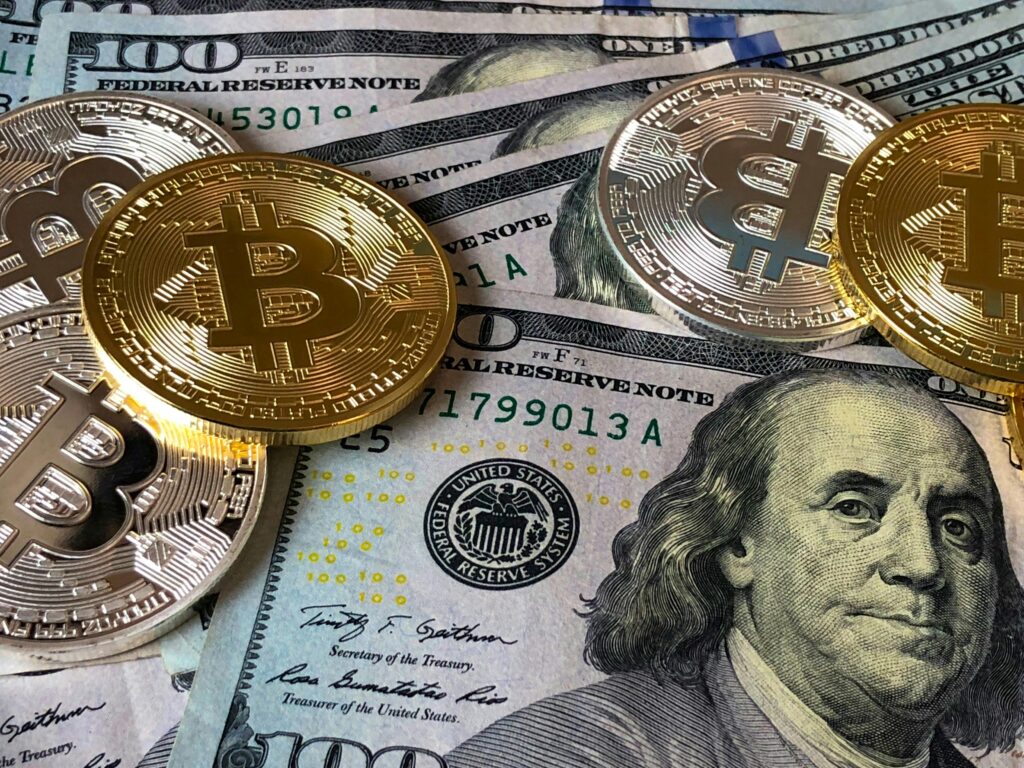 pexels-photo-730547-730547 A close-up photo depicting Bitcoin coins on top of US dollar bills, symbolizing finance and cryptocurrency.